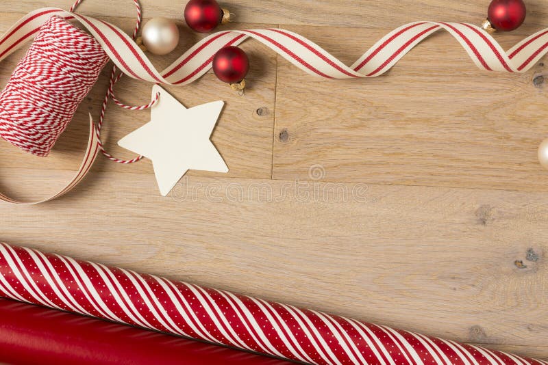 Documento de envoltorio para regalos de la Navidad y fuentes de las cintas sobre el fondo de madera imagenes de archivo Documento de envoltorio para regalos de la Navidad y fuentes de las cintas sobre el fondo de madera imagenes de archivo