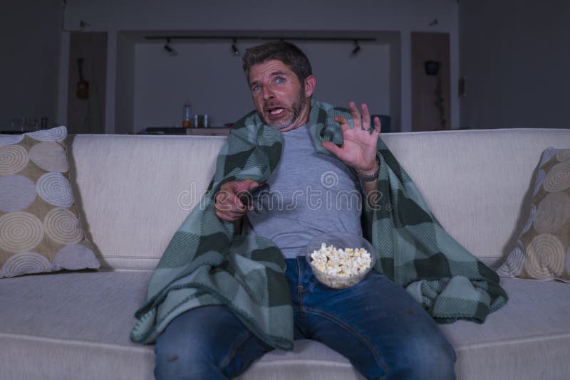 Doen schrikken en grappige mens alleen bij nacht in woonkamerlaag het letten op verschrikkings enge film in televisie die en popc royalty-vrije stock foto's Doen schrikken en grappige mens alleen bij nacht in woonkamerlaag het letten op verschrikkings enge film in televisie die en popc royalty-vrije stock foto's