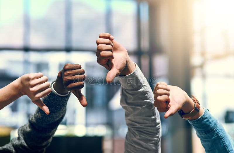 That doesnt go down well with us. a group of unrecognizable businesspeople gesturing thumbs down. stock image