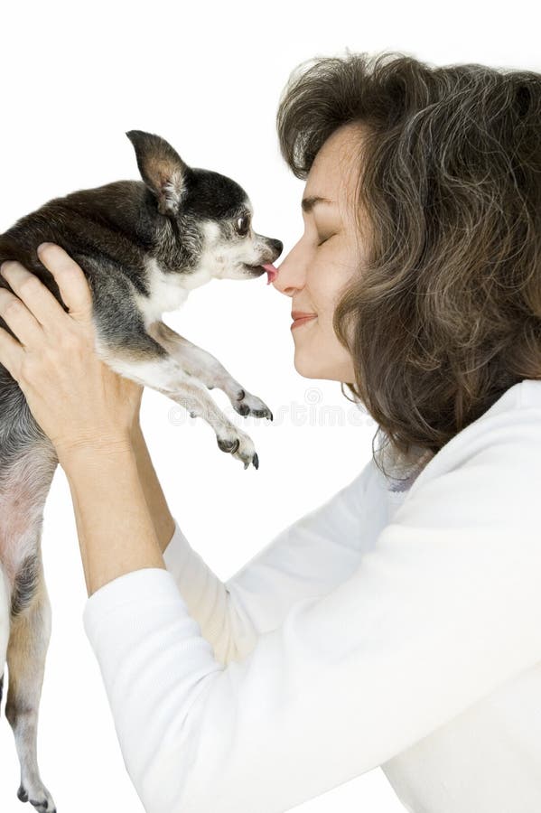 Žena so zatvorenými očami a pol úsmev, dostane bozk z čiernej a bielej hračka chihuahua.