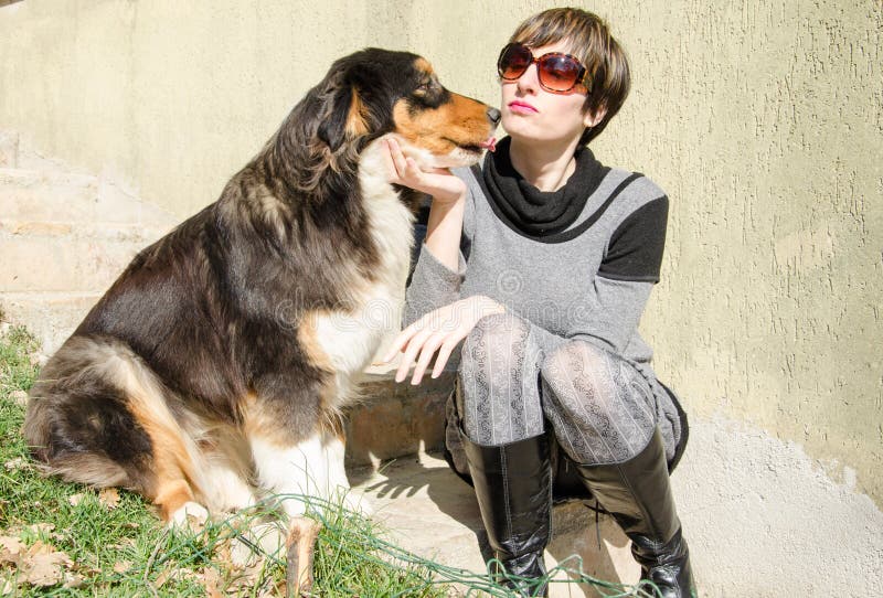 Australian shepherd dog kissing fashion lady