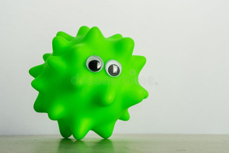 A green dog toy with eyes as a symbol of a virus o bacteria