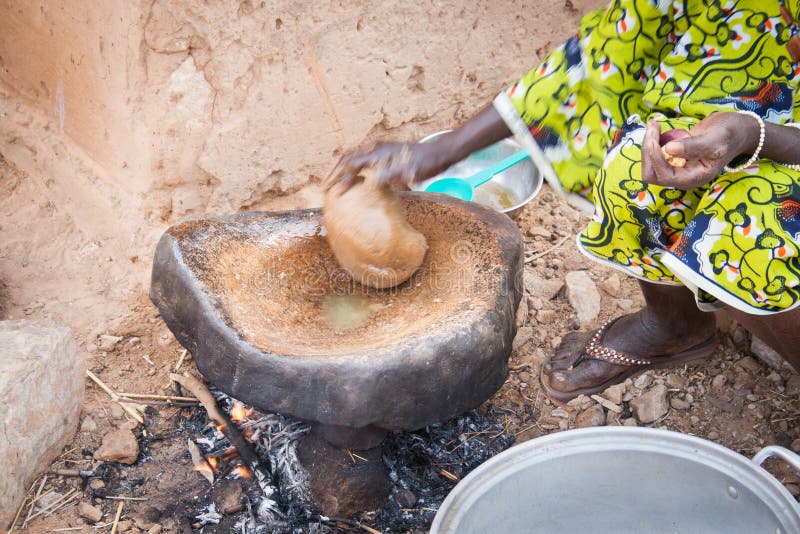 Dogon woman preparing food using peanut paste royalty free stock photos