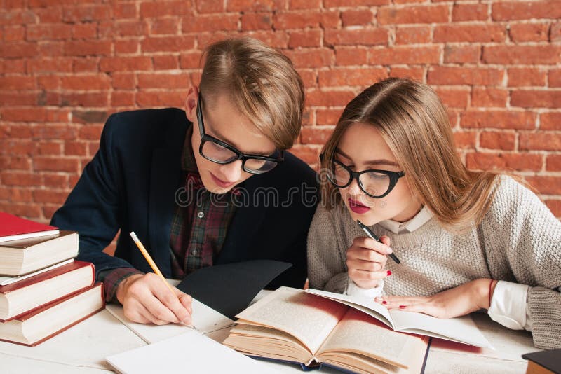 Doi studenți care citesc cu atenție manualul stock photos
