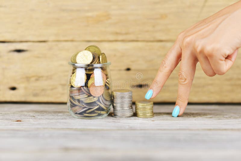 Woman’s fingers climbing stairs of money to a full of money transparent jar, financial growth concept. Woman’s fingers climbing stairs of money to a full of money transparent jar, financial growth concept