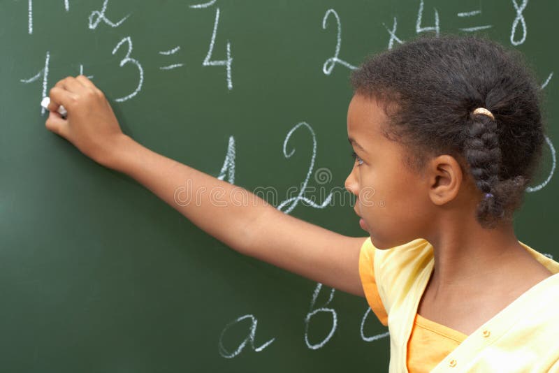 Doing sums. Portrait of smart schoolchild standing at blackboard and doing sums Doing sums. Portrait of smart schoolchild standing at blackboard and doing sums