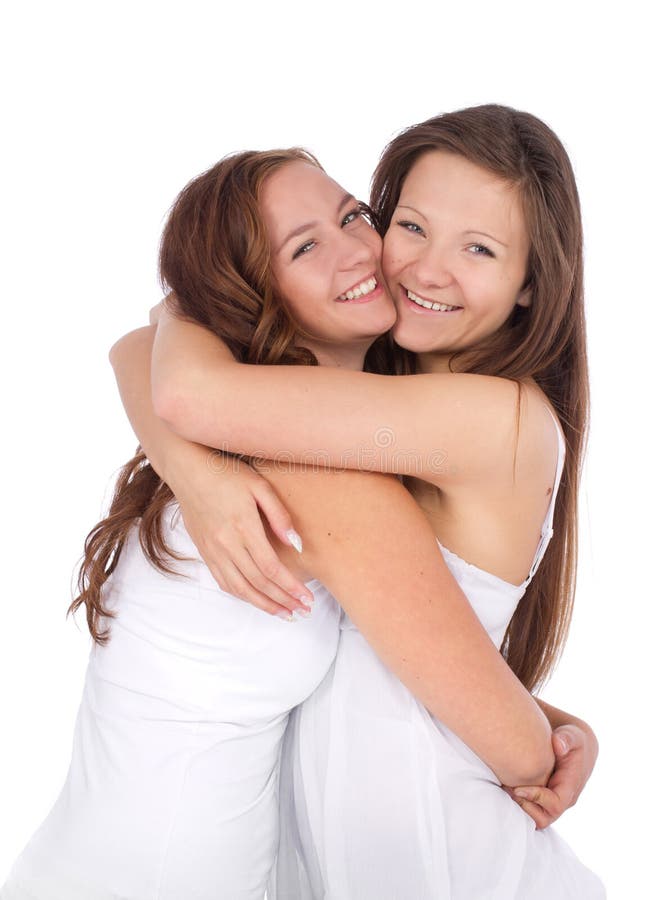 Dois adolescentes que sorriem e que abraçam