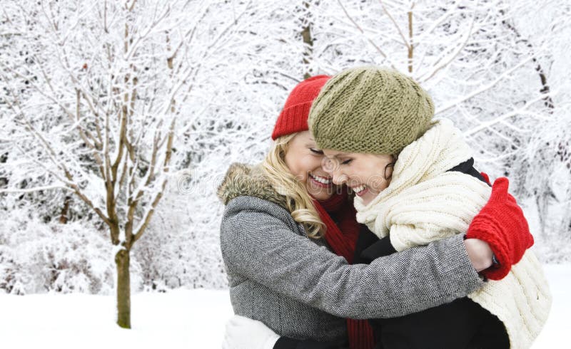 Dois amigos de menina que abraçam fora no inverno imagem de stock Dois amigos de menina que abraçam fora no inverno imagem de stock