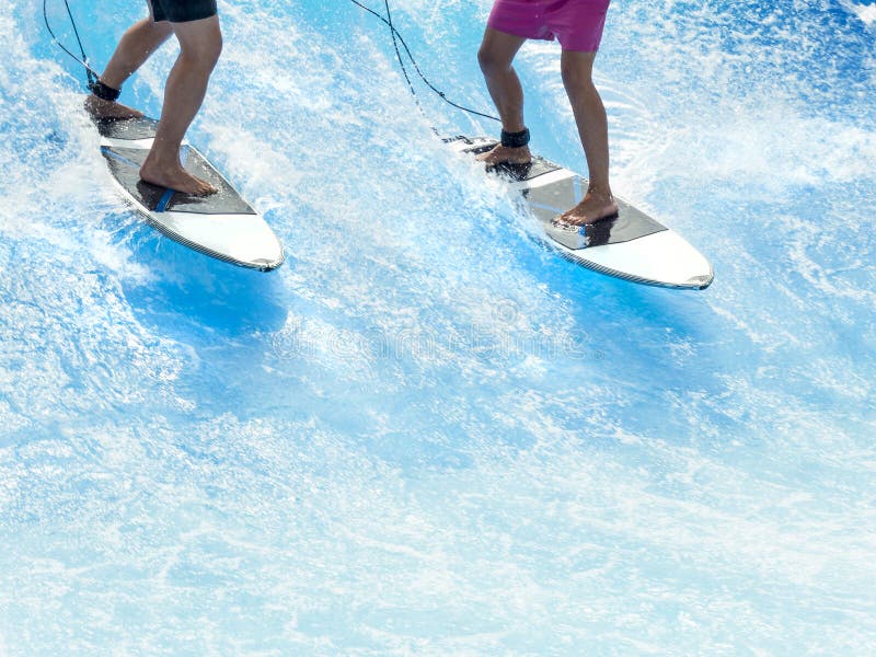 Two friends surfing. Surf lessons. Close up of legs and surfboards. Two friends surfing. Surf lessons. Close up of legs and surfboards