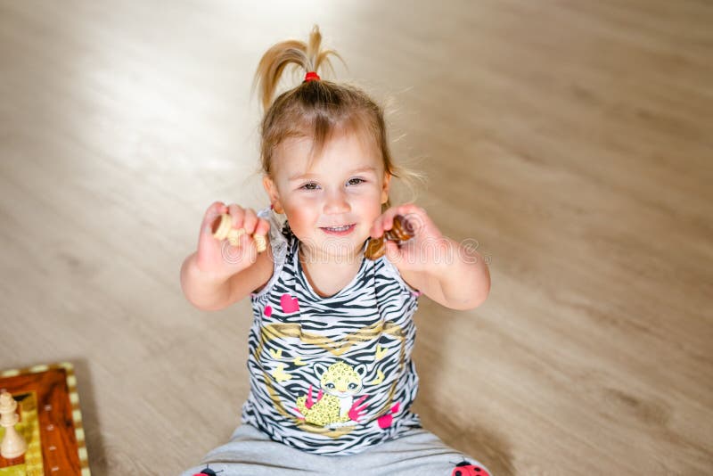 Feliz Bebê Loira Com Duas Pequenas Tranças Em Camiseta Branca E Um Kit De  Calças Jeans Sentado Sobre O Fundo Da Grama Verde Foto de Stock - Imagem de  pouco, inocência: 143643548