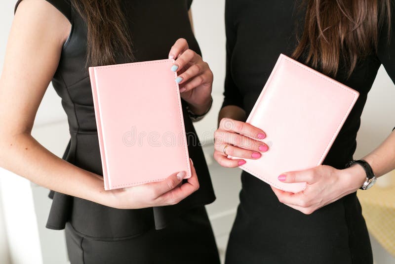 Dois cadernos do negócio da posse das meninas à disposição fotos de stock Dois cadernos do negócio da posse das meninas à disposição fotos de stock