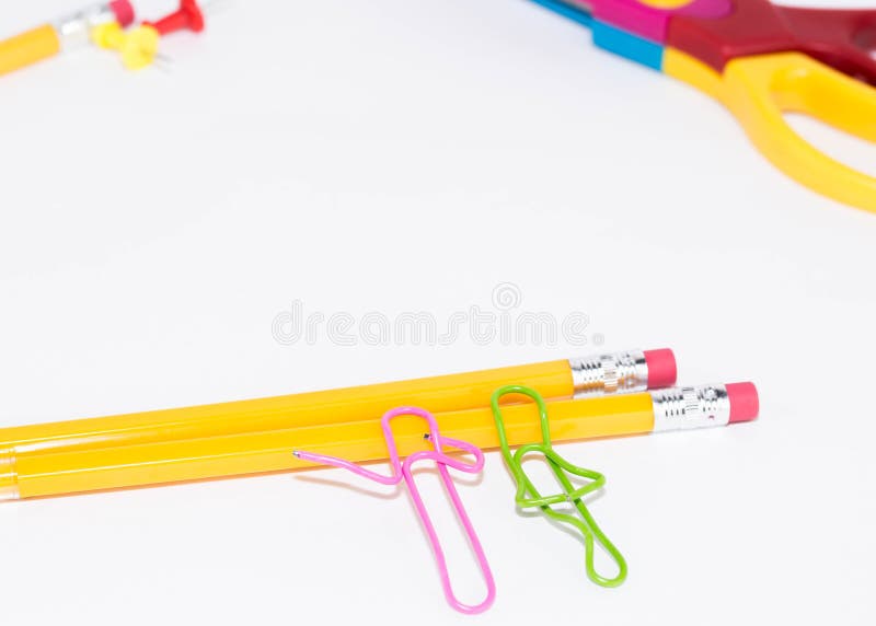 Dois clipes de papel que falam ao encontrar-se em um assoalho branco e em um lápis Vida diminuta da escola e de volta ao conceito fotografia de stock Dois clipes de papel que falam ao encontrar-se em um assoalho branco e em um lápis Vida diminuta da escola e de volta ao conceito fotografia de stock