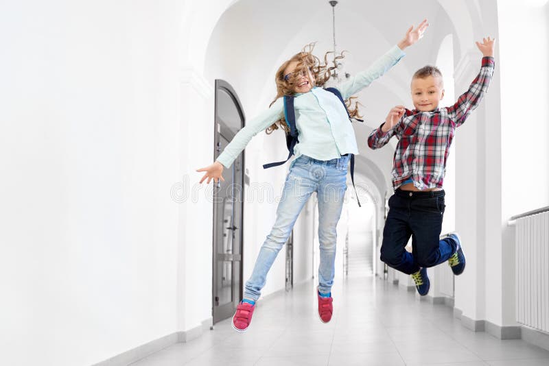 Dois colegas menino e menina dos melhores amigos que saltam acima foto de stock Dois colegas menino e menina dos melhores amigos que saltam acima foto de stock