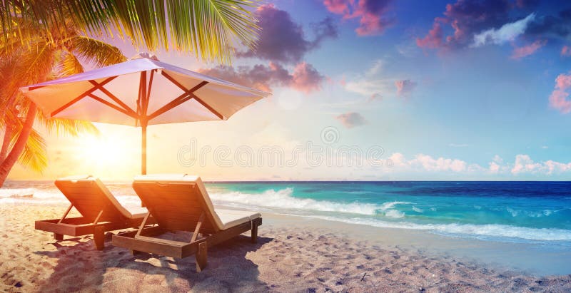 Dois Deckchairs sob o parasol na praia tropical imagem de stock royalty free Dois Deckchairs sob o parasol na praia tropical imagem de stock royalty free