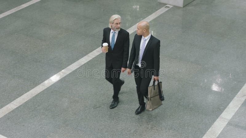 Dois executivos empresariais que chegam no prédio de escritórios moderno