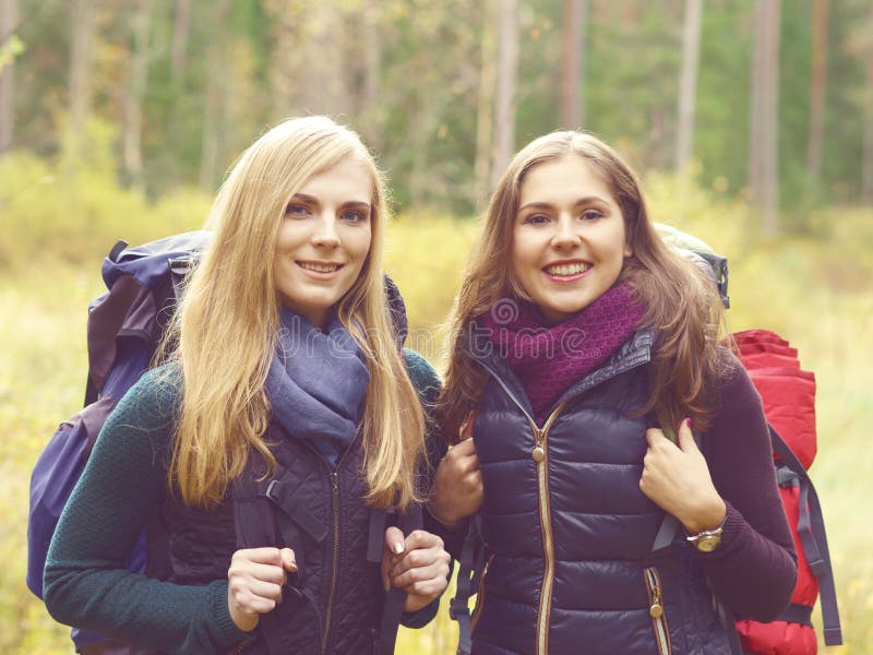 Dois felizes e meninas bonitas que andam na floresta e nos pântanos acampamento fotografia de stock Dois felizes e meninas bonitas que andam na floresta e nos pântanos acampamento fotografia de stock