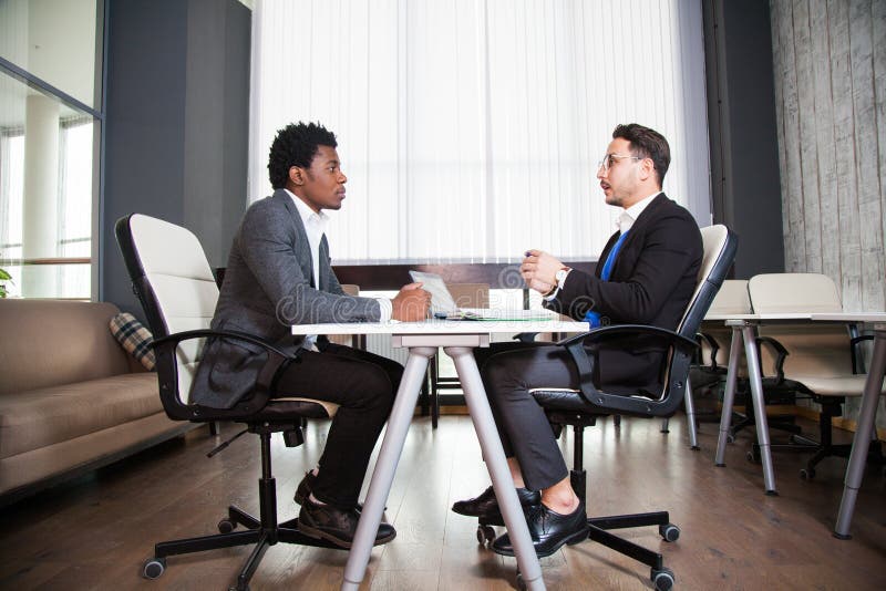 Dois homens de negócios novos, mesa branca, entrevista de trabalho, trabalhos de equipa foto de stock royalty free Dois homens de negócios novos, mesa branca, entrevista de trabalho, trabalhos de equipa foto de stock royalty free