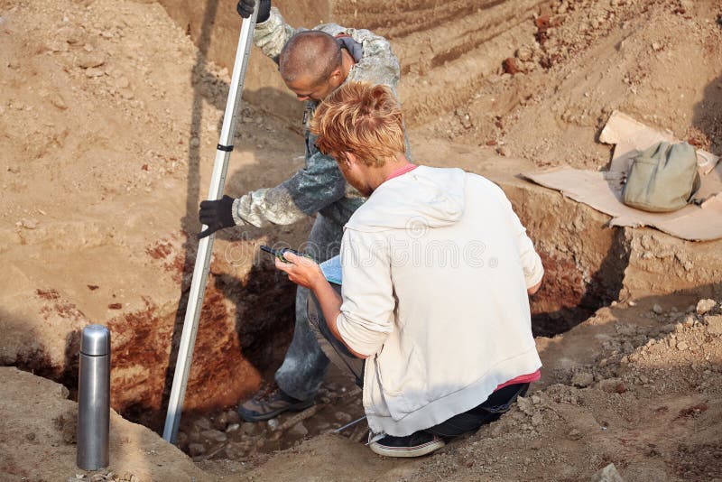 Dois homens no trabalho fora, no processo do escavador Escavações Archaeological imagens de stock Dois homens no trabalho fora, no processo do escavador Escavações Archaeological imagens de stock