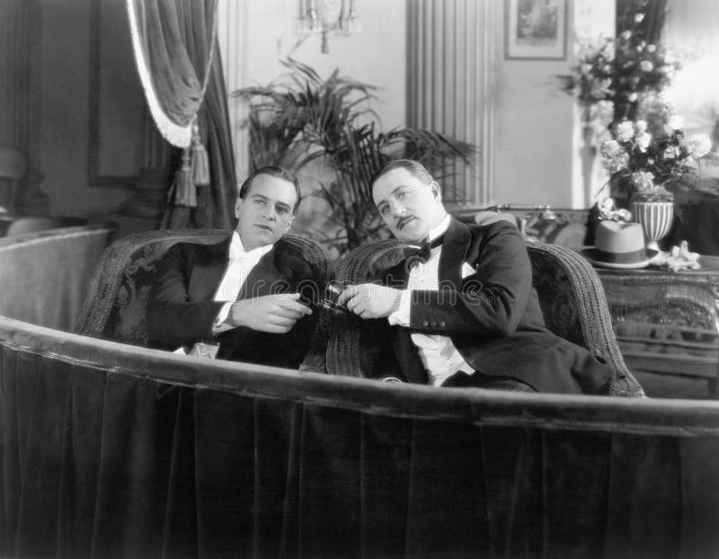 Two men in formal attire sitting together in a theater box (All persons depicted are no longer living and no estate exists. Supplier grants that there will be no model release issues.). Two men in formal attire sitting together in a theater box (All persons depicted are no longer living and no estate exists. Supplier grants that there will be no model release issues.)