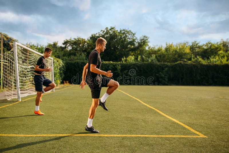 Dois jogadores de futebol masculinos deitado na grama do campo