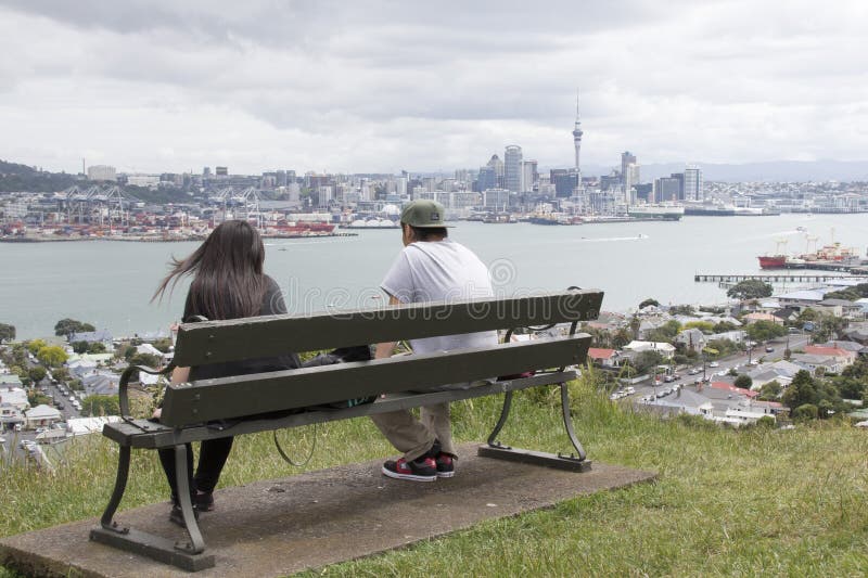 Dois jovens a observar a cidade e o porto de Auckland a partir de Devonport fotografia de stock