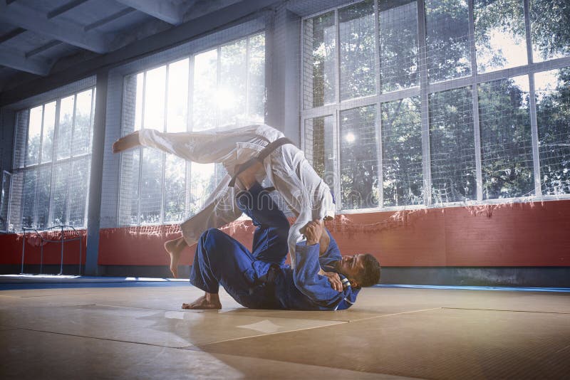 Dois lutadores do judô que mostram a habilidade técnica quando as artes marciais praticando em uma luta baterem imagem de stock royalty free Dois lutadores do judô que mostram a habilidade técnica quando as artes marciais praticando em uma luta baterem imagem de stock royalty free