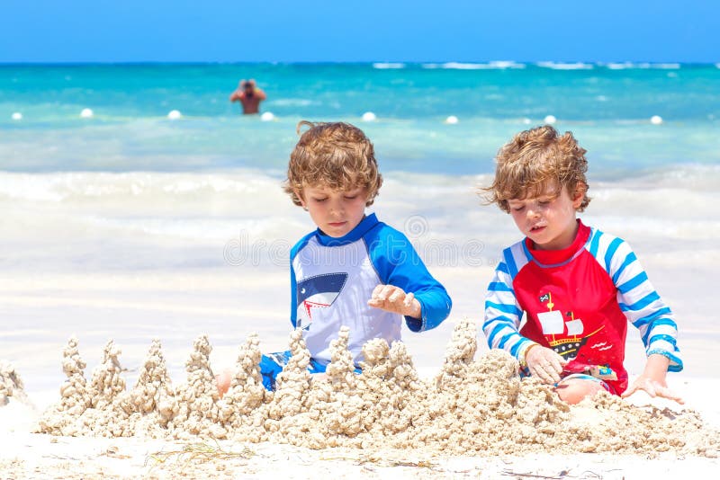 Dois meninos das crian?as que t?m o divertimento com constru??o de um castelo da areia na praia tropical na ilha Jogo saud?vel da imagem de stock Dois meninos das crian?as que t?m o divertimento com constru??o de um castelo da areia na praia tropical na ilha Jogo saud?vel da imagem de stock