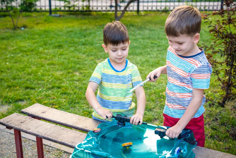 Meninos Que Jogam O Jogo Popular Beyblade Com Partes Superiores De