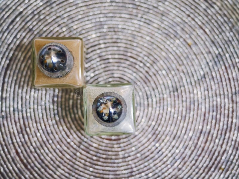 Dois pequenos pimentões de forma quadrada e saleiros numa superfície de mesa redonda Foco seletivo Vista superior imagem de stock Dois pequenos pimentões de forma quadrada e saleiros numa superfície de mesa redonda Foco seletivo Vista superior imagem de stock