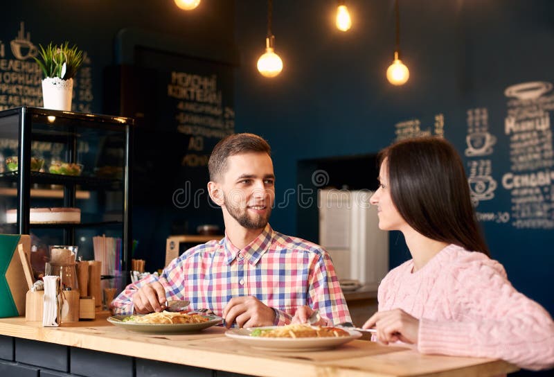 Dois pessoas de homem novo e mulher na cafetaria que apreciam a despesa do tempo um com o otro Conceito romântico do conhecimento imagem de stock Dois pessoas de homem novo e mulher na cafetaria que apreciam a despesa do tempo um com o otro Conceito romântico do conhecimento imagem de stock