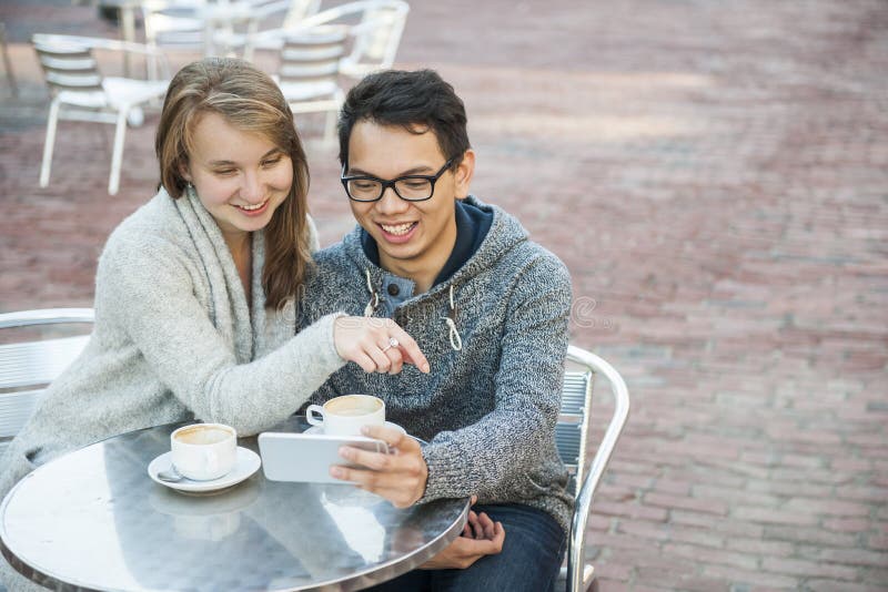 Dois povos com o smartphone no café imagens de stock Dois povos com o smartphone no café imagens de stock