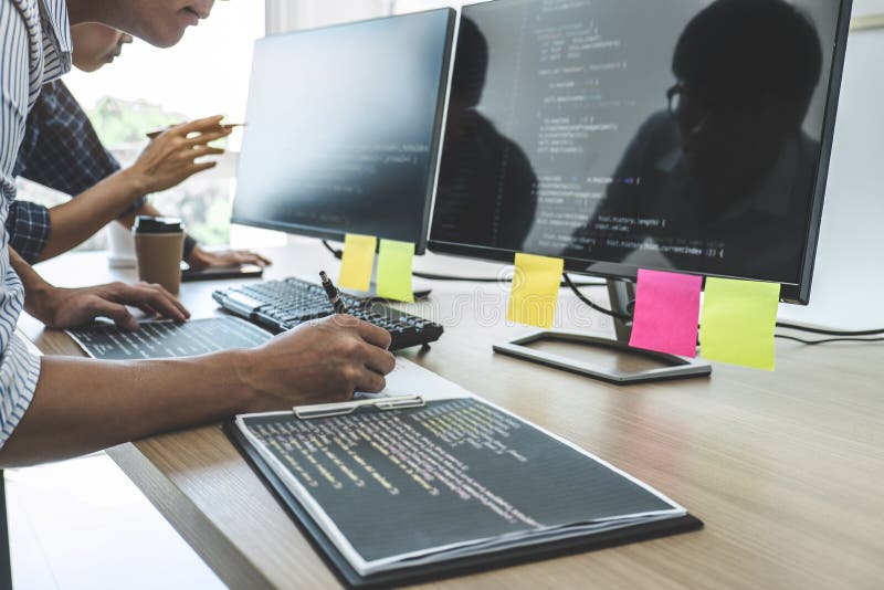 Dois programadores profissionais que cooperam na programa??o e no Web site tornando-se que trabalham em um software desenvolvem o imagem de stock Dois programadores profissionais que cooperam na programa??o e no Web site tornando-se que trabalham em um software desenvolvem o imagem de stock