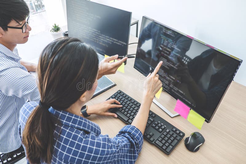 Dois programadores profissionais que cooperam na programação e no Web site tornando-se que trabalham em um software desenvolvem o fotografia de stock Dois programadores profissionais que cooperam na programação e no Web site tornando-se que trabalham em um software desenvolvem o fotografia de stock
