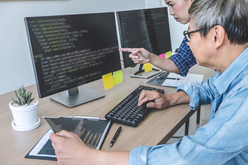 Dois programadores profissionais que cooperam na programação e no Web site tornando-se que trabalham em um software desenvolvem o imagens de stock royalty free Dois programadores profissionais que cooperam na programação e no Web site tornando-se que trabalham em um software desenvolvem o imagens de stock royalty free