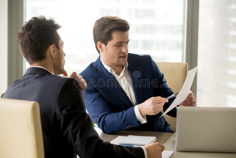 Dois sócios comerciais sérios que discutem o original, homens de negócios n imagens de stock royalty free Dois sócios comerciais sérios que discutem o original, homens de negócios n imagens de stock royalty free