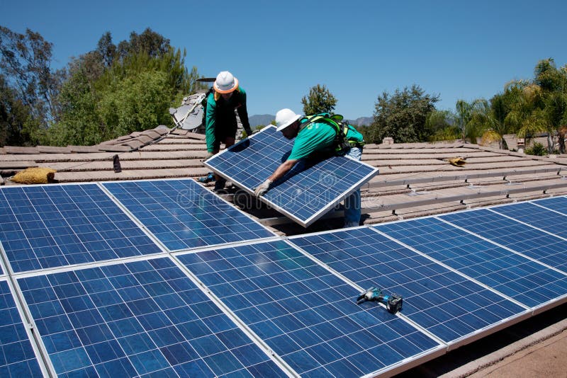 Two male solar workers install solar panels on home in Oak View, Southern California. Two male solar workers install solar panels on home in Oak View, Southern California