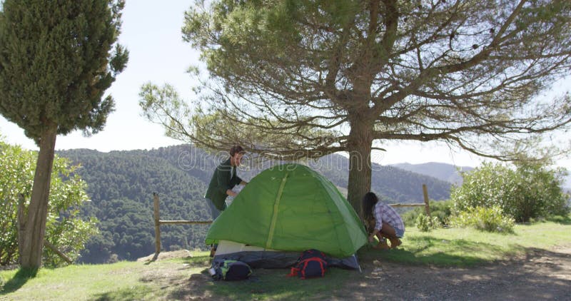 Dois viajantes colocando tenda