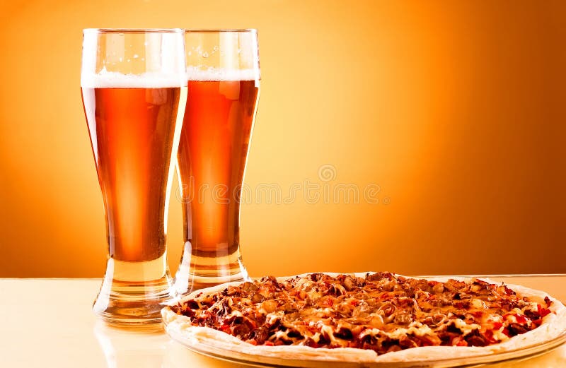 Dois vidros da cerveja e da pizza fotografia de stock Dois vidros da cerveja e da pizza fotografia de stock