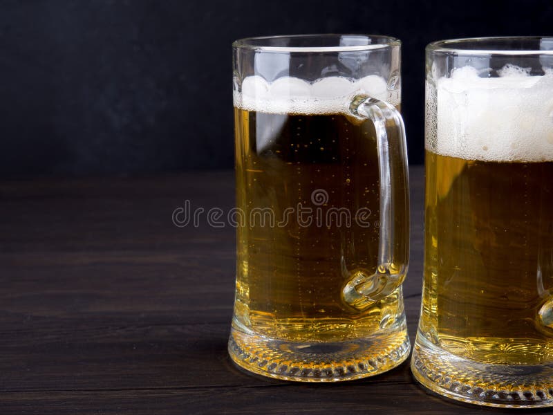 Dois vidros da cerveja pilsen serviram nas pranchas de madeira velhas, copyspace para o texto fotografia de stock royalty free Dois vidros da cerveja pilsen serviram nas pranchas de madeira velhas, copyspace para o texto fotografia de stock royalty free