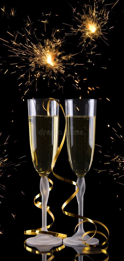 Two champagne glasses on black background with holiday sparkler. Two champagne glasses on black background with holiday sparkler