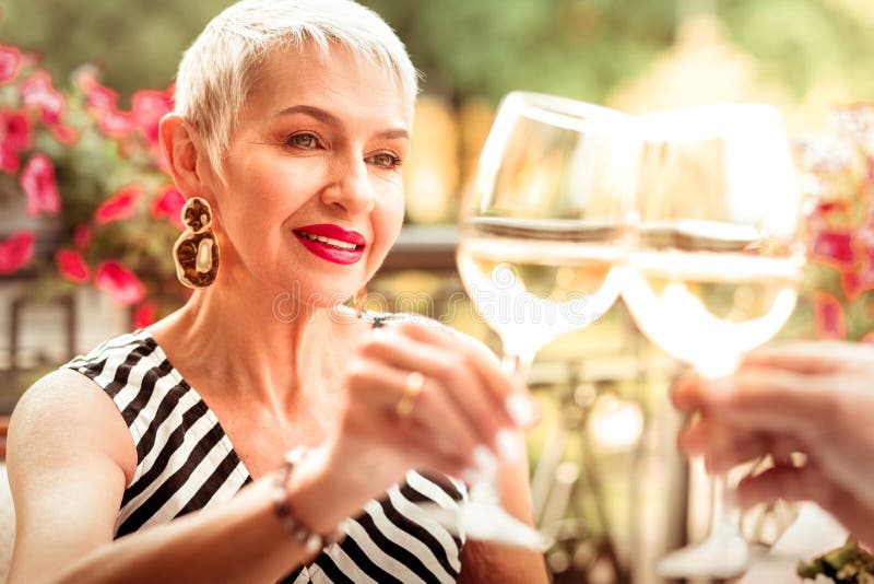 Wearing massive earrings. Mature women wearing massive earrings drinking wine with husband. Wearing massive earrings. Mature women wearing massive earrings drinking wine with husband