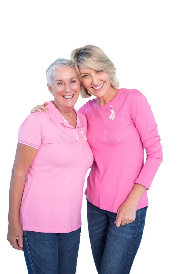 Mature women wearing pink tops and breast cancer ribbons on white background. Mature women wearing pink tops and breast cancer ribbons on white background