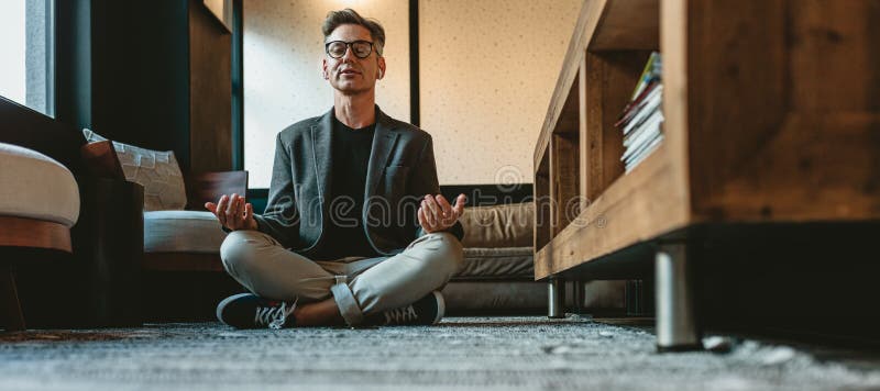 Dojrzały biznesmen w gabinecie medytacji jogi