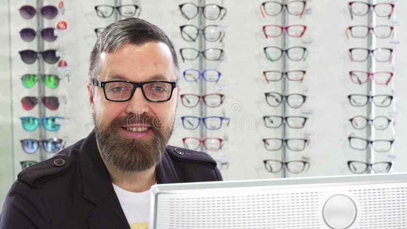 Dojrzały optometrist pracuje na komputerze przy jego sklepem zdjęcie royalty free Dojrzały optometrist pracuje na komputerze przy jego sklepem zdjęcie royalty free