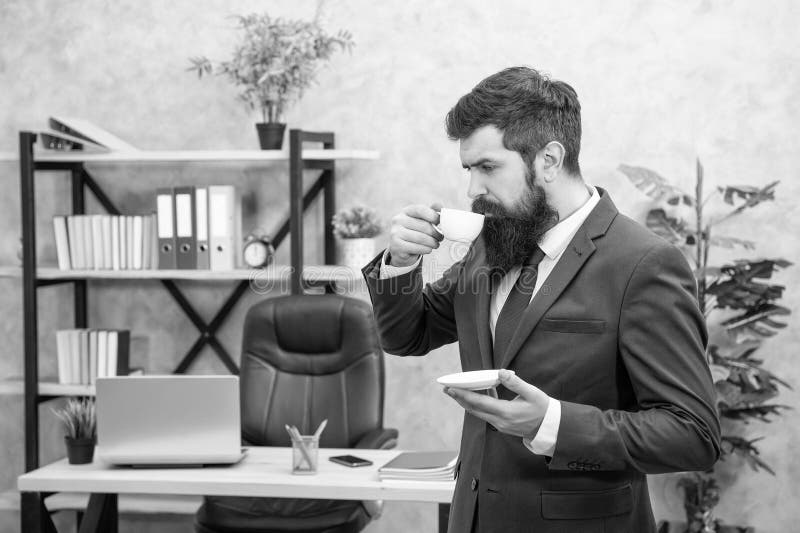 Dojrzały przedsiębiorca w kurtce ma przerwę na kawę w biurze biznesowym zdjęcia stock
