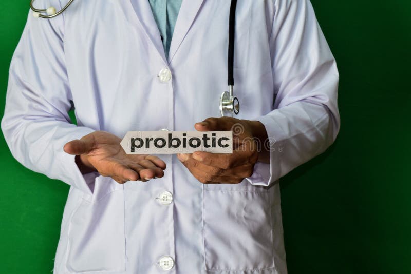 Doktor, der auf grünem Hintergrund steht Halten Sie den Probiotic Papiertext lizenzfreies stockfoto Doktor, der auf grünem Hintergrund steht Halten Sie den Probiotic Papiertext lizenzfreies stockfoto