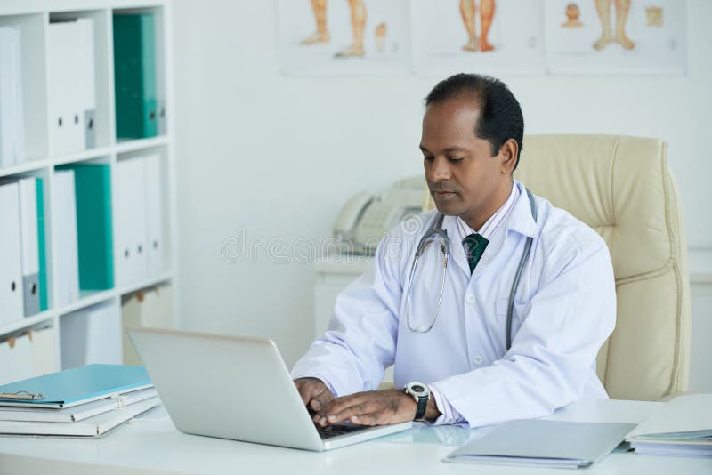 Doktor, der auf Laptop schreibt stockfotografie Doktor, der auf Laptop schreibt stockfotografie