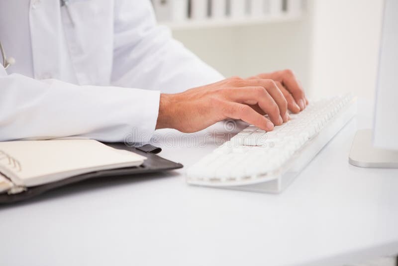 Doktor, der auf Tastatur schreibt und lizenzfreies stockfoto Doktor, der auf Tastatur schreibt und lizenzfreies stockfoto