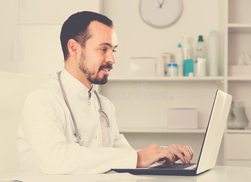 Doktor för ung man som är klar att motta klienter royaltyfria foton Doktor för ung man som är klar att motta klienter royaltyfria foton