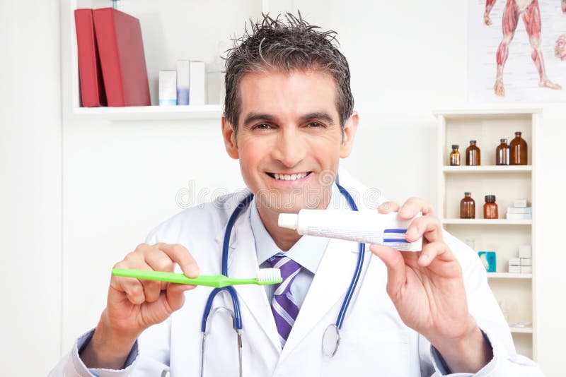 Doktor Holding Tooth Brush och tandkräm arkivfoton Doktor Holding Tooth Brush och tandkräm arkivfoton